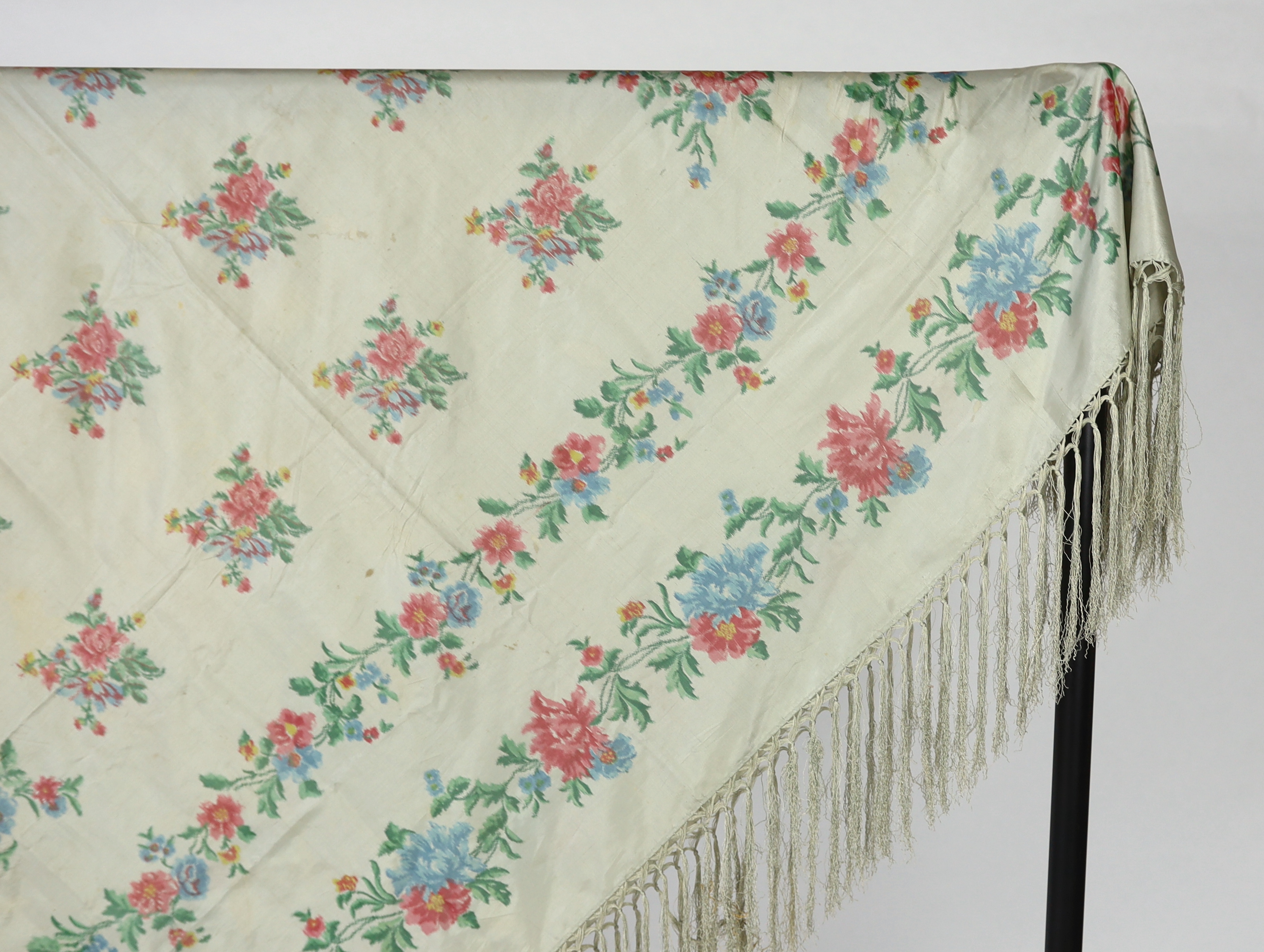 A French silk shawl, c.1800-1840, of a type modelled by Madame Recamier in the painting by François Gerard, printed on the warp thread into a rose pattern, with long fringing, 174 x 170cm